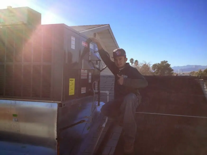 HVAC technician performing AC Tune-Up on a rooftop unit in London